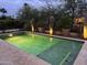 Beautifully lit swimming pool with stone accents and mature landscaping, creating a private backyard oasis at 16935 W Cambridge Ave, Goodyear, AZ 85395