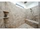 Walk-in shower with marble tile, rainfall shower head, and built-in bench seating at 1713 W Cottonwood Ln, Phoenix, AZ 85045