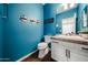 Charming powder room with a vanity, a toilet, and decorative accents against blue walls at 1713 W Cottonwood Ln, Phoenix, AZ 85045