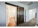 Bedroom entryway featuring a decorative sliding barn door and an open-concept bathroom at 1713 W Cottonwood Ln, Phoenix, AZ 85045