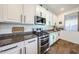 Modern kitchen features stainless steel appliances, granite countertops, and white cabinets at 1713 W Cottonwood Ln, Phoenix, AZ 85045