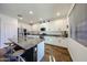 Modern kitchen with white cabinets, granite countertops, stainless steel appliances, and island with seating at 1713 W Cottonwood Ln, Phoenix, AZ 85045