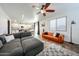 Bright living space with gray and orange couch, ceiling fan and tile floors throughout the home at 1713 W Cottonwood Ln, Phoenix, AZ 85045