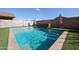 Inviting swimming pool with baja shelf, stone surround, and clear blue water, perfect for relaxation at 1713 W Cottonwood Ln, Phoenix, AZ 85045