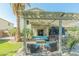 Outdoor living space featuring a pergola, stylish seating, lush greenery, and a built-in television at 17751 W Bloomfield Rd, Surprise, AZ 85388