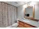 Bathroom featuring a granite countertop, wooden vanity, framed mirror, and patterned shower curtain at 200 E Southern Ave # 316, Tempe, AZ 85282