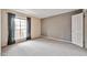 Bedroom with neutral carpeting, a large window with curtains, and a gray accent wall at 200 E Southern Ave # 316, Tempe, AZ 85282