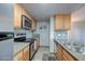 Corner view of kitchen showcasing stainless steel appliances and gray tile backsplash at 200 E Southern Ave # 316, Tempe, AZ 85282