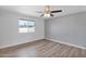 This bedroom offers wood floors, a ceiling fan, neutral paint, and a window with views at 2026 E Duke Dr, Tempe, AZ 85283