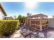 Backyard featuring a wooden lattice structure surrounded by lush greenery and stone pathways at 20640 N 100Th Ln, Peoria, AZ 85382