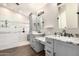 Modern bathroom with dual sinks, granite countertops, a vanity, and a tiled walk-in shower at 20640 N 100Th Ln, Peoria, AZ 85382