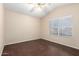 Bright bedroom features wood-look floors, a ceiling fan, and a window with blinds at 20640 N 100Th Ln, Peoria, AZ 85382