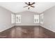 A spacious bedroom featuring a vaulted ceiling, two windows with shutters, and dark wood-look tile flooring at 20640 N 100Th Ln, Peoria, AZ 85382