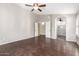 Spacious primary bedroom features modern ceiling fan and doorway to a bathroom with a tiled shower at 20640 N 100Th Ln, Peoria, AZ 85382