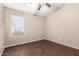 Bright bedroom features wood-look floors, a ceiling fan, and a window with blinds at 20640 N 100Th Ln, Peoria, AZ 85382