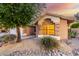 Beige single-story house featuring stone accents and desert landscaping with large river rock and gravel at 20640 N 100Th Ln, Peoria, AZ 85382