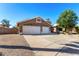 A beige single-story home with a three-car garage, stone accents, desert landscaping, and extended driveway at 20640 N 100Th Ln, Peoria, AZ 85382