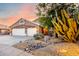 A beige single-story home with a three-car garage, stone accents, and desert landscaping at 20640 N 100Th Ln, Peoria, AZ 85382