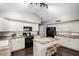 Modern kitchen featuring granite countertops, white cabinets, and a functional center island with stools at 20640 N 100Th Ln, Peoria, AZ 85382