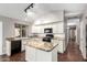 An open kitchen with granite countertops, white cabinets, black appliances, and wood-look floors at 20640 N 100Th Ln, Peoria, AZ 85382