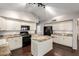 A spacious kitchen with white cabinets, black appliances, granite countertops, and a center island at 20640 N 100Th Ln, Peoria, AZ 85382