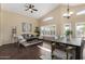 Open-concept living room and dining space featuring high ceilings and large windows with plantation shutters at 20640 N 100Th Ln, Peoria, AZ 85382