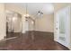 Open living space featuring dark wood-look tile floors, an arched doorway, and neutral walls at 20640 N 100Th Ln, Peoria, AZ 85382