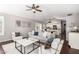 Bright living room featuring a ceiling fan, modern decor, and seamless flow to the kitchen at 20640 N 100Th Ln, Peoria, AZ 85382