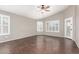 Spacious living room with dark wood-look tile flooring and many windows with white shutters at 20640 N 100Th Ln, Peoria, AZ 85382