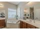 Bathroom with vanity and soaking tub under window at 21359 E Camacho Rd, Queen Creek, AZ 85142