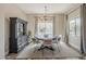 Well-lit dining room with gray walls, chandelier, hardwood floors, and large windows with curtains at 21359 E Camacho Rd, Queen Creek, AZ 85142