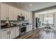 Modern kitchen featuring white cabinets, stainless steel appliances, and dark countertops and hardwood floors at 21359 E Camacho Rd, Queen Creek, AZ 85142