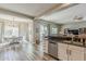 Open-concept kitchen featuring stainless steel dishwasher, countertops, and views to dining and living areas at 21359 E Camacho Rd, Queen Creek, AZ 85142