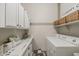 Bright laundry room with modern appliances, storage, and white cabinetry at 21359 E Camacho Rd, Queen Creek, AZ 85142