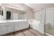 A modern bathroom with double sinks, a soaking tub, and a glass-enclosed shower at 21622 N Backus Dr, Maricopa, AZ 85138