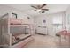 bedroom with a bunk bed and decoratively adorned walls and a ceiling fan at 21622 N Backus Dr, Maricopa, AZ 85138