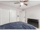 A primary bedroom with a ceiling fan, dresser and closet and a navy blue bed at 21622 N Backus Dr, Maricopa, AZ 85138