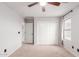 Neutral bedroom with a ceiling fan, large window, and sliding door closet at 21622 N Backus Dr, Maricopa, AZ 85138