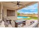 Relaxing covered patio with comfortable seating overlooking the sparkling pool and landscaped backyard at 21622 N Backus Dr, Maricopa, AZ 85138