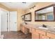 Bathroom with double sinks, light wood cabinets, and granite countertops at 224 N 236Th Ave, Buckeye, AZ 85396