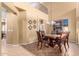 Dining room features a striking chandelier, and a decorative table, adjacent to an open-concept living space at 224 N 236Th Ave, Buckeye, AZ 85396