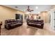 Open-concept living room with leather sofas and tile floors at 224 N 236Th Ave, Buckeye, AZ 85396