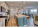 Modern kitchen with a large island, stainless steel appliances, and adjacent dining area filled with natural light at 22474 E Lawndale E Pl, Queen Creek, AZ 85142