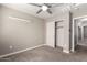 Neutral bedroom with a fan and a closet featuring a white door, offering a simple and comfortable space at 240 W Juniper Ave # 1146, Gilbert, AZ 85233