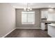 Bright dining area featuring a stylish chandelier, tile floors and adjacent kitchen with granite countertops at 240 W Juniper Ave # 1146, Gilbert, AZ 85233