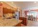 Bright kitchen with granite countertops, stainless steel appliances, and an island with a sink and extra storage at 2612 N 161St Ave, Goodyear, AZ 85395