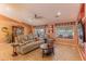 Comfortable living room with a leather sofa, a ceiling fan, wood-look floors and sliding glass doors at 2612 N 161St Ave, Goodyear, AZ 85395