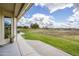 View from covered patio of green backyard that extends to community greenspace with mature trees and lake at 2662 S Springwood S Blvd # 458, Mesa, AZ 85209