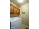 A laundry room featuring a washer and dryer, with wooden cabinets mounted above and a tile floor at 2662 S Springwood S Blvd # 458, Mesa, AZ 85209