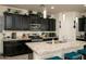 Modern kitchen featuring a granite island, stainless appliances, and contemporary pendant lighting at 2849 W Apollo Rd, Phoenix, AZ 85041